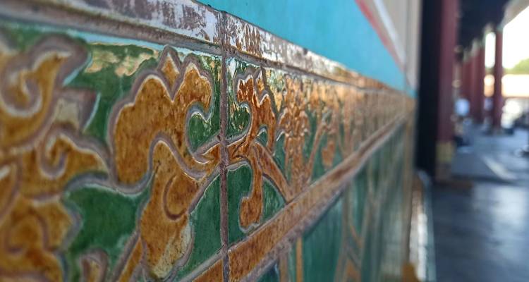 Primer plano de azulejos vidriados coloridos con intrincados patrones de dragones en la Ciudad Prohibida de Pekín.