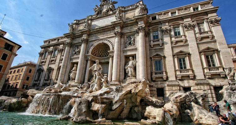 The ornate Trevi Fountain cascades in front of a grand Baroque façade in Rome.