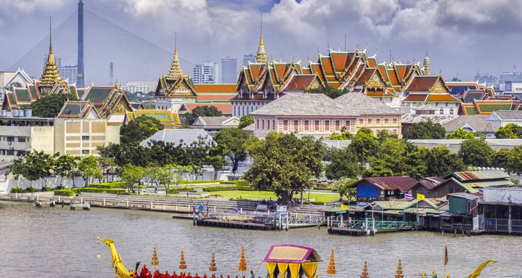 Panorama du complexe du Grand Palais et de l'horizon de Bangkok avec la rivière Chao Phraya au premier plan sous des nuages dramatiques.