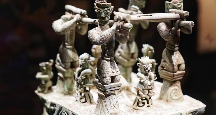 Intricate ancient Chinese bronze figurines displayed in a museum setting