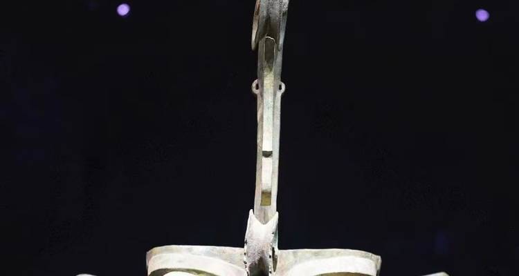 Tall ceremonial bronze tree artifact showcased against a dark background