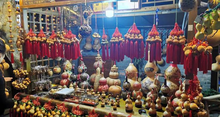 Vibrant night-market stall selling decorated gourds and red tassels