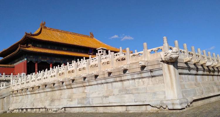 Ornate marble balustrades and golden-roofed hall of Beijing’s Forbidden City against a clear blue sky