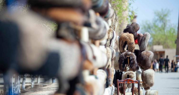 Rangée de chapeaux de fourrure exposés sur des poteaux en bois avec une faible profondeur de champ le long d'un marché de rue.