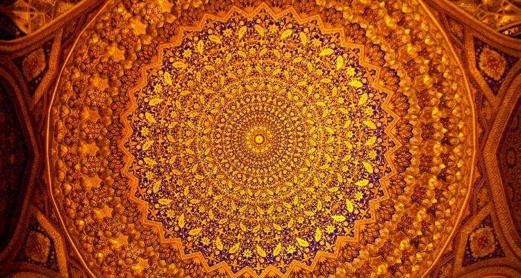 Médaillon de plafond orné doré avec des motifs floraux et géométriques complexes rayonnant vers l'extérieur.