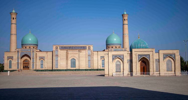 Vue frontale large du complexe Hazrati Imam avec de multiples dômes turquoise sous un ciel bleu.