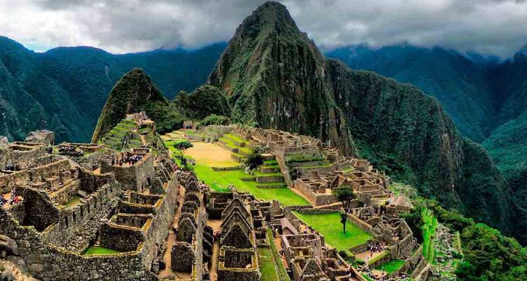 Vista aérea icónica de las ruinas de Machu Picchu bajo un cielo nublado y dramático.