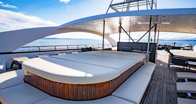 Upper deck hot tub area with panoramic sea view under clear skies.