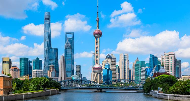 Vue du ciel bleu éclatant de l'horizon de Shanghai avec la Tour Perle d'Orient au-dessus d'un canal et d'un pont.