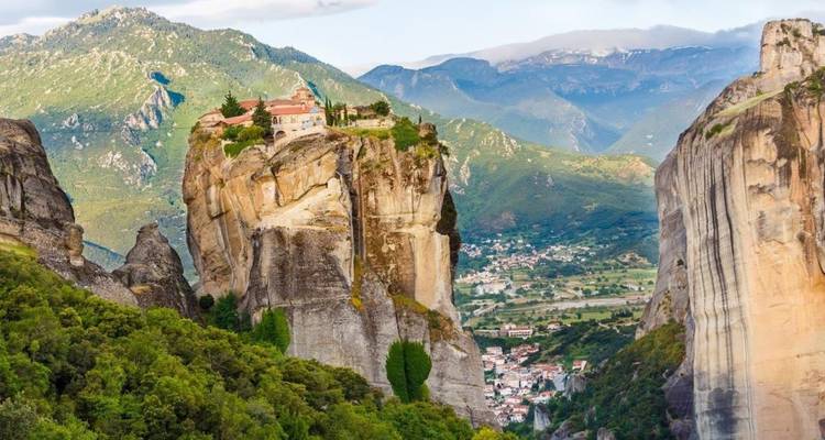 Isolated Meteora monastery perched high on a steep pillar with valley below