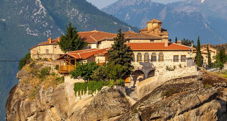 Steinkloster auf dramatischen Meteora-Klippen mit Bergkulisse thronend