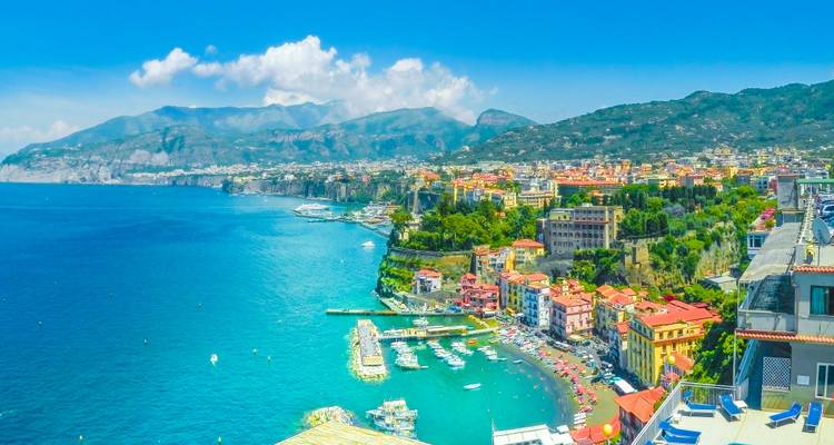 Panoramic view over Sorrento’s colorful coast, turquoise sea and distant mountains.