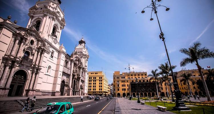 Colonial buildings, palm trees and a classic car taxi line Lima’s Plaza Mayor under a bright sky