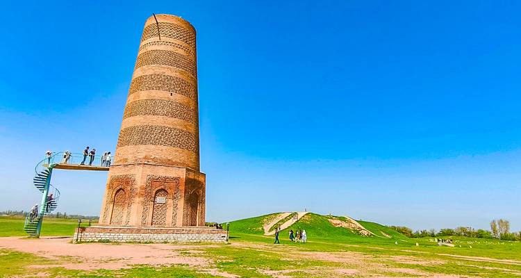 Histórica Torre Burana de ladrillo rojo que se alza en una llanura abierta con mirador de escalera en espiral