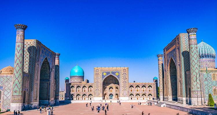 La icónica plaza Registán en Samarcanda con madrasas ornamentadas y cúpulas azules bajo un cielo despejado