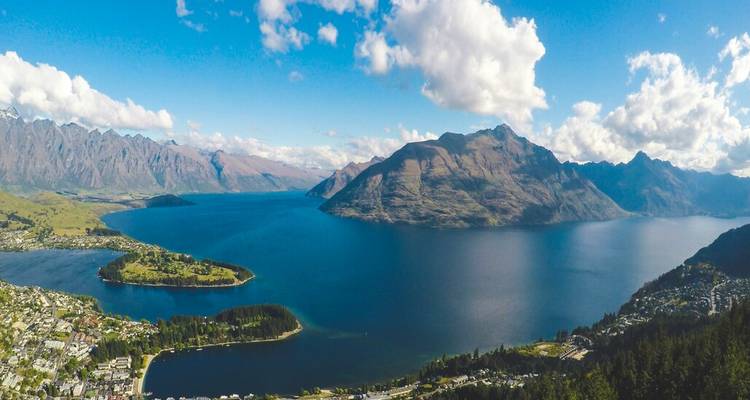 Panoramisch luchtfoto van het diepblauwe Lake Wakatipu omringd door dramatische alpenketens.