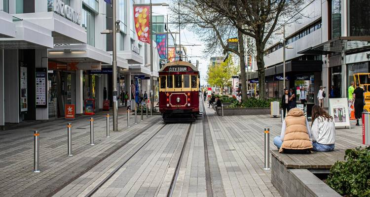 Vintage rode tram rijdt langs voetgangerswinkelstraat in het stadscentrum van Christchurch.