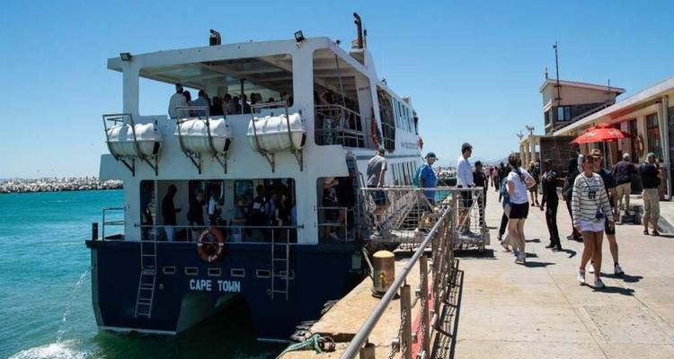 Passenger ferry named 'Cape Town' docked at a pier with tourists boarding under bright sunshine
