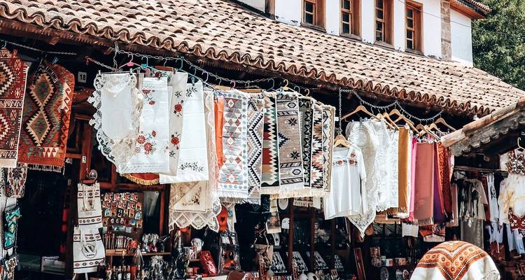 Rij van sierlijke textiel en kantwerk hangend buiten traditionele marktkramen