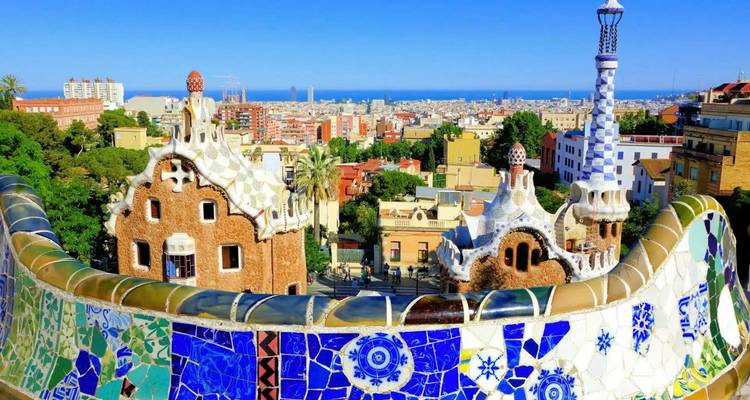 Icónica terraza de mosaico del Parque Güell con vistas al paisaje urbano de Barcelona y el Mar Mediterráneo