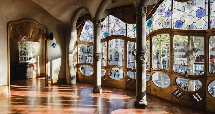 Interior soleado de la Casa Batlló con ventanas curvas y vidrieras de colores que dan al Passeig de Gràcia