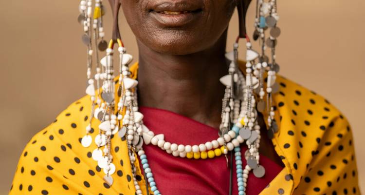 Portrait en gros plan d'une femme masaï parée de perles colorées et d'ornements en argent sur un arrière-plan doux.