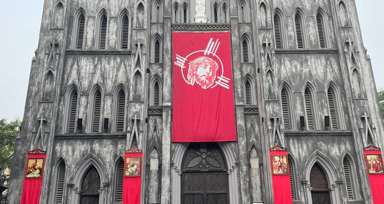 Façade gothique de la cathédrale Saint-Joseph drapée de bannières rouges saisissantes à Hanoï.