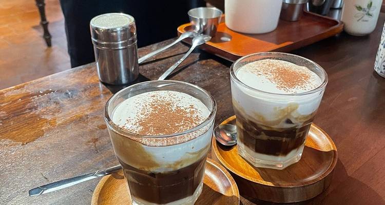 Gros plan de deux verres de café aux œufs vietnamien traditionnel surmonté de mousse crémeuse et de cacao.