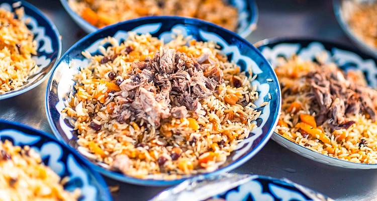 Traditioneel Centraal-Aziatisch rijstgerecht plov geserveerd op gepatroneerde blauwe borden