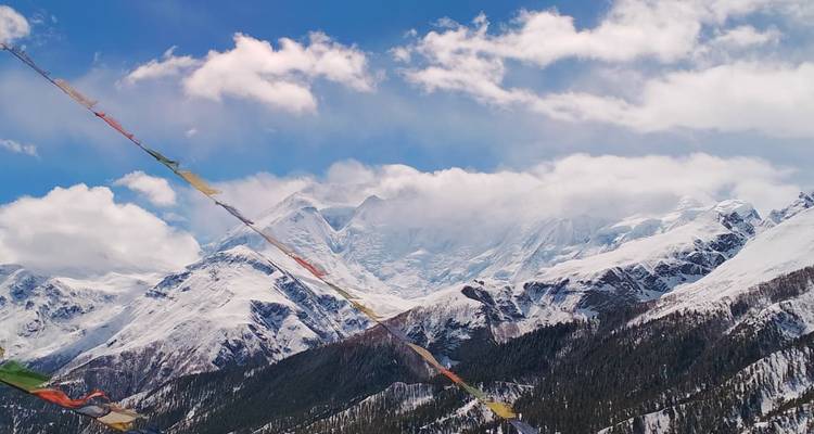 Himalayas nevados panorámicos con nubes flotando alrededor de las cumbres