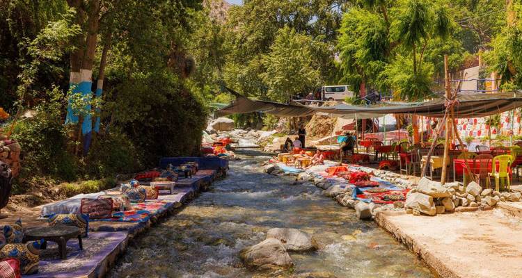 Flusscafé-Terrassen mit bunten Teppichen und Kissen entlang des Ourika-Flusses.