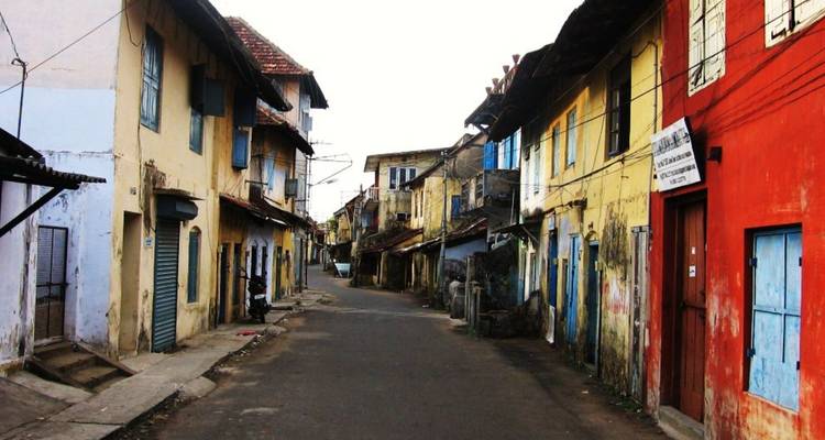 Farbenfrohe schmale Straße gesäumt von alternden Kolonialgebäuden in Fort Kochi