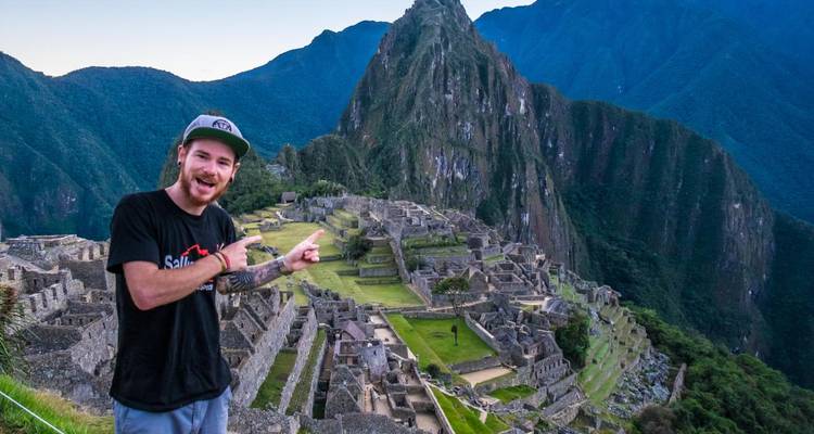 El viajero señala emocionadamente hacia el panorama clásico de Machu Picchu.