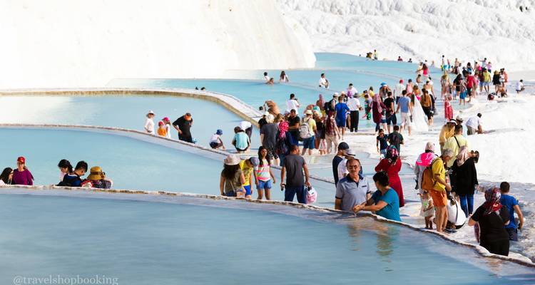 Multitudes de visitantes caminando por las piscinas escalonadas turquesas de las terrazas de travertino de Pamukkale.