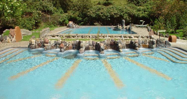 Thermalbäder im Freien mit Steinrändern, umgeben von Grün in Papallacta.