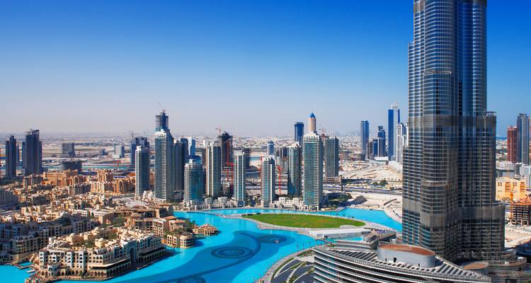 Vue aérienne du centre-ville de Dubaï avec le lac turquoise de la Burj Khalifa et les gratte-ciel environnants s'étendant jusqu'à l'horizon du désert.