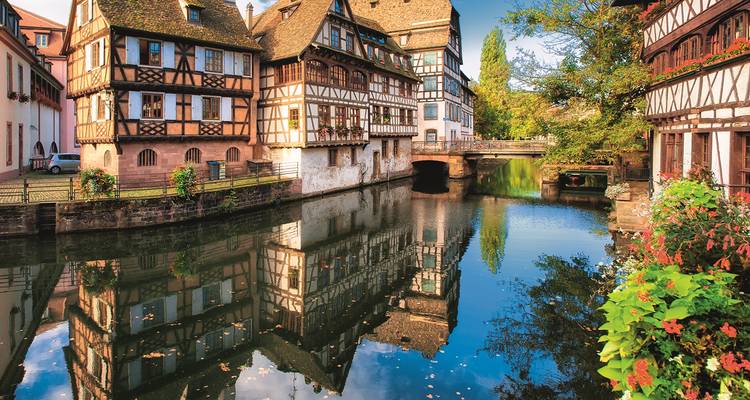 Traditionelle Fachwerkhäuser von Straßburgs Petite France säumen einen ruhigen Kanal mit lebendigen Spiegelungen.