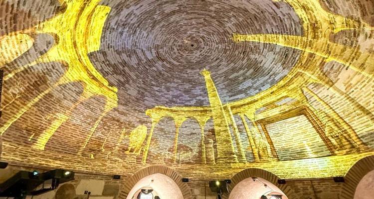 Innere Kuppelprojektion zeigt goldene antike Säulen an der Backsteindecke eines Amphitheater-Museums.