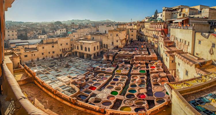 Panoramisch uitzicht over de kleurrijke leerlooierij kuilen van Fes omringd door door de zon gedroogde stadsgebouwen.