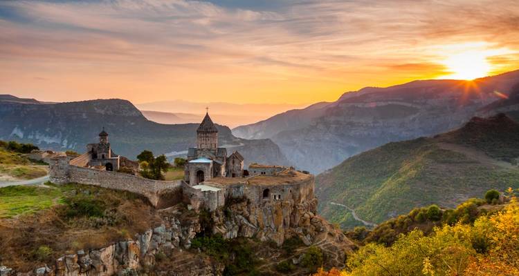 Le monastère de Tatev s'accroche au bord d'une falaise spectaculaire au lever du soleil avec les vallées brumeuses du Caucase en contrebas.