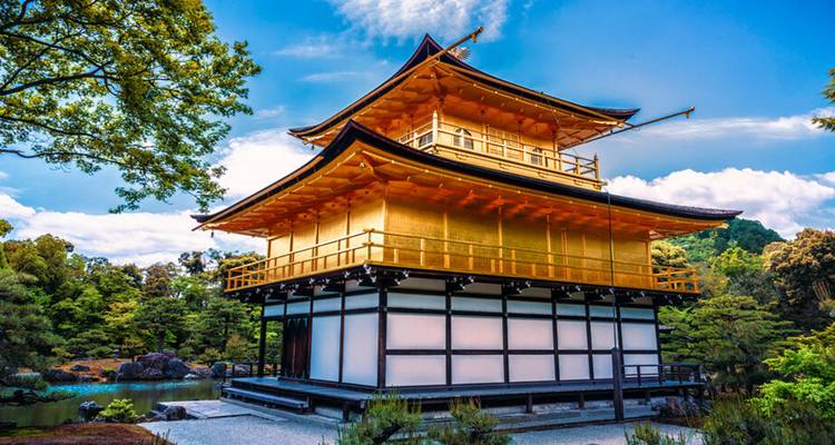 Kyoto's glinsterende Gouden Paviljoen weerkaatst zonlicht naast rustige tuinen en een vijver.