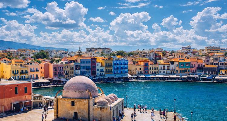 Colorful Venetian harbor of Chania with waterfront tavernas, domed mosque and vivid buildings along the quay.