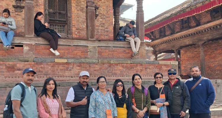 Tour group stands in front of ornate brick temple facade in Bhaktapur.