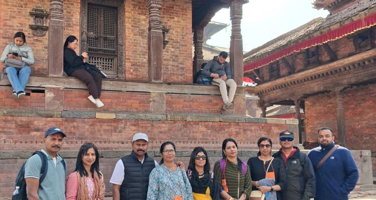 Repeat group photo of travellers by historic brick architecture in Bhaktapur.