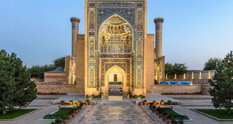 Entrée élégante de mausolée de style persan richement décorée de carreaux bleus et dorés aux motifs complexes.