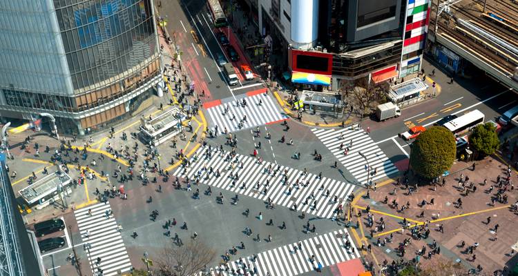 Vista aérea del famoso cruce de Shibuya abarrotado de peatones y rodeado de altos edificios modernos.
