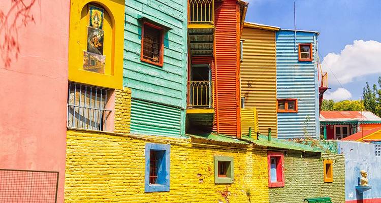 Fila de edificios de chapa ondulada pintados de colores brillantes en el barrio de La Boca