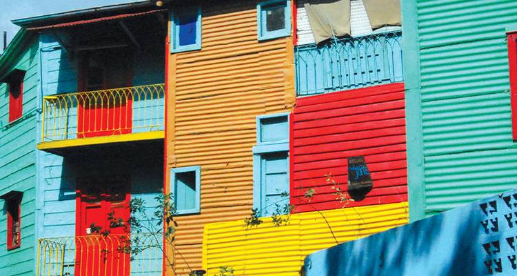 Primer plano de fachadas de madera multicolores con listones llamativos en rojo, amarillo y turquesa