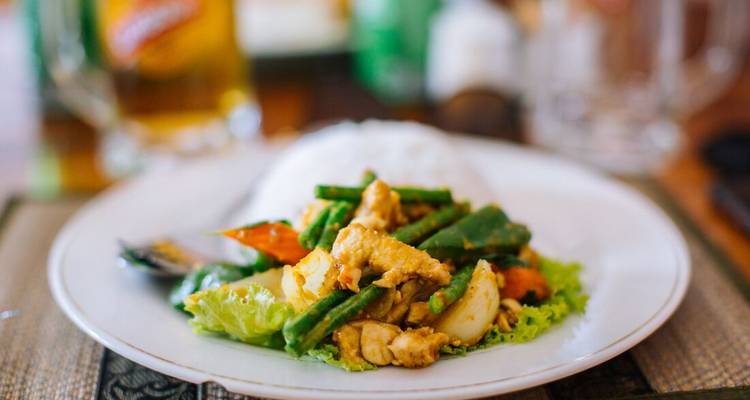 Close-up of a Cambodian stir-fry with rice neatly plated in a restaurant.