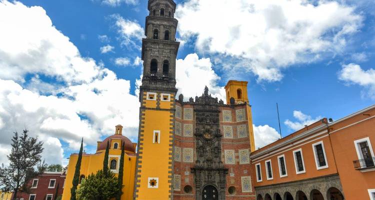 Clocher jaune et façade d'église coloniale ornementée à Puebla.